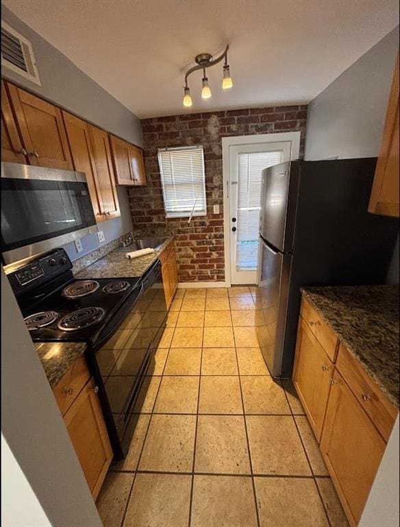 561 Formwalt St SW Unit 8, Atlanta, GA 30312 - kitchen with brick wall, sink, dark stone countertops, light tile patterned floors, and stainless steel appliances