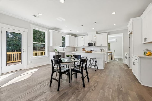 dining room featuring wood-type flooring and ornamental molding