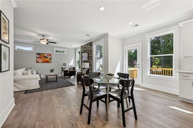 dining space with ceiling fan, crown molding, and light hardwood / wood-style floors