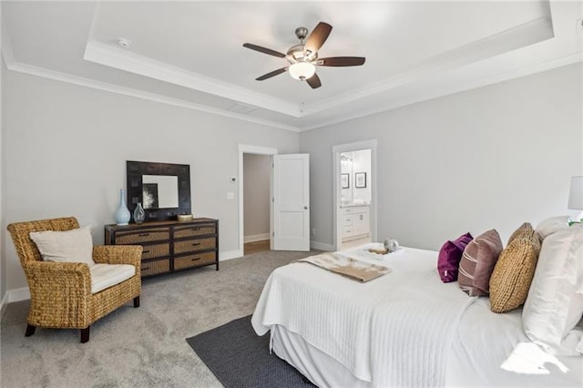 bedroom with ceiling fan, a raised ceiling, ornamental molding, light carpet, and ensuite bathroom