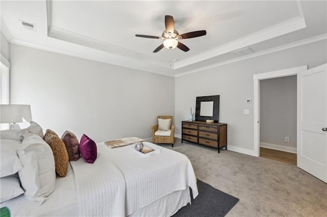 bedroom featuring a raised ceiling, crown molding, light carpet, and ceiling fan