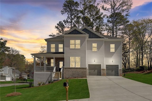 view of front of home featuring a lawn, covered porch, and a garage