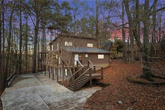 back house at dusk with a deck and a garage