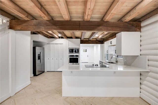 kitchen featuring white cabinets, sink, kitchen peninsula, and stainless steel appliances