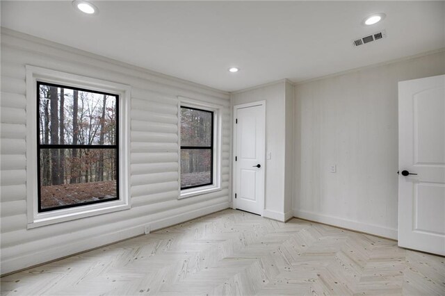 empty room featuring ornamental molding and light parquet floors