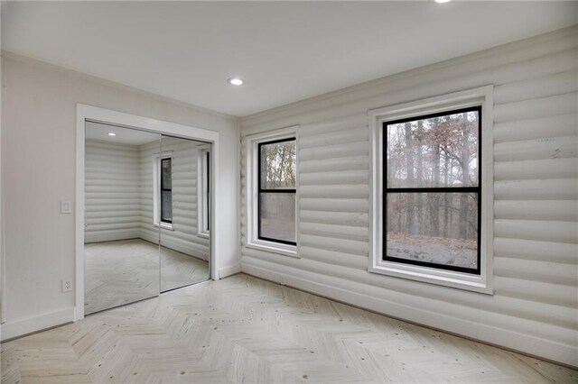 empty room with light parquet flooring and plenty of natural light