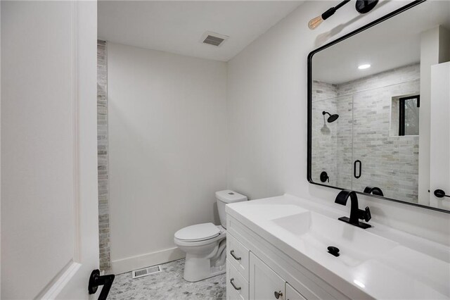 bathroom with tile patterned floors, toilet, vanity, and walk in shower