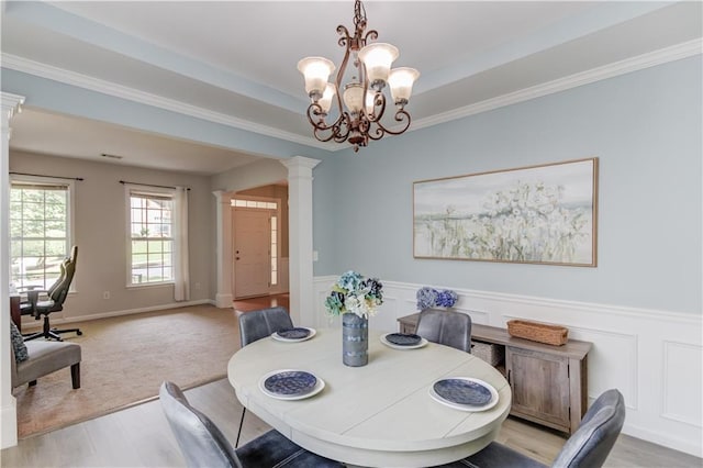 4092 Duran Ln, Auburn, GA 30011 - dining room with ornate columns, light wood-style flooring, a chandelier, a wainscoted wall, and ornamental molding