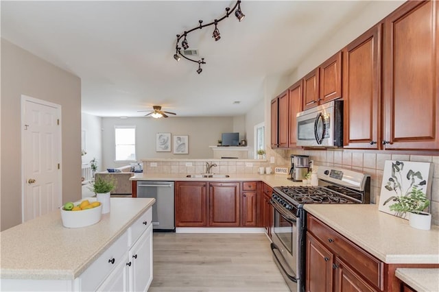 4092 Duran Ln, Auburn, GA 30011 - kitchen with stainless steel appliances, light countertops, light wood-style flooring, a ceiling fan, and decorative backsplash