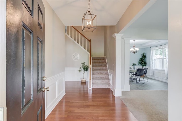 4092 Duran Ln, Auburn, GA 30011 - foyer with a chandelier, stairs, a wainscoted wall, a decorative wall, and wood finished floors
