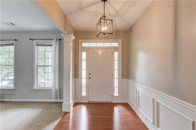 4092 Duran Ln, Auburn, GA 30011 - entrance foyer featuring ornate columns, wood finished floors, a chandelier, and wainscoting