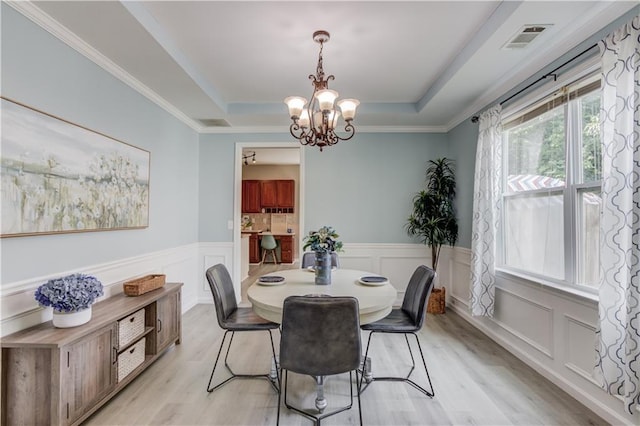 4092 Duran Ln, Auburn, GA 30011 - dining space with a raised ceiling, light wood-style floors, a chandelier, a wainscoted wall, and a decorative wall