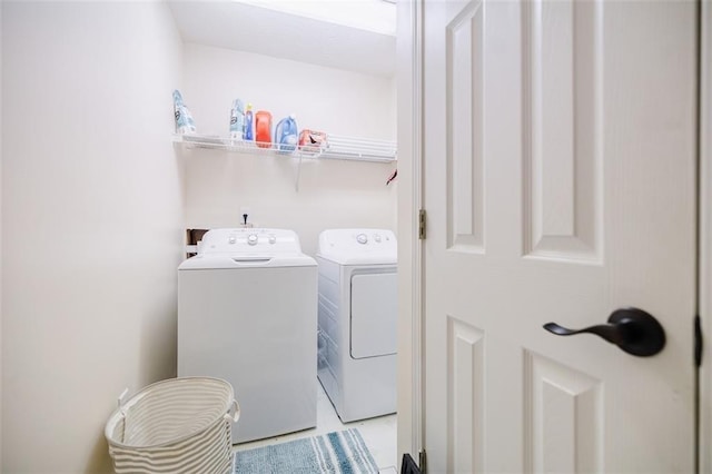 clothes washing area with separate washer and dryer and light tile patterned floors