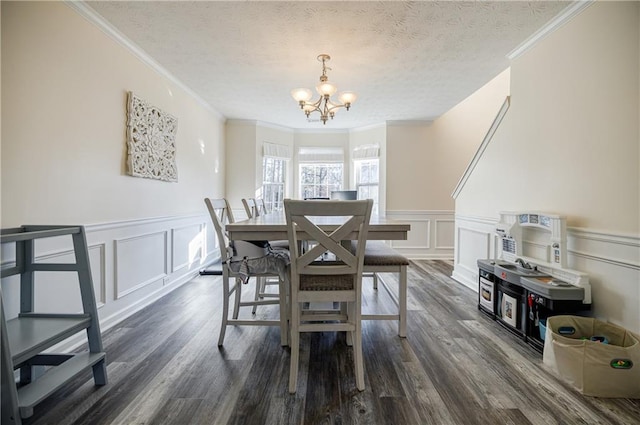 dining room with crown molding, dark hardwood / wood-style flooring, a textured ceiling, and an inviting chandelier