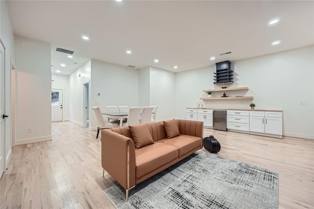 living room featuring baseboards, recessed lighting, visible vents, and light wood-style floors