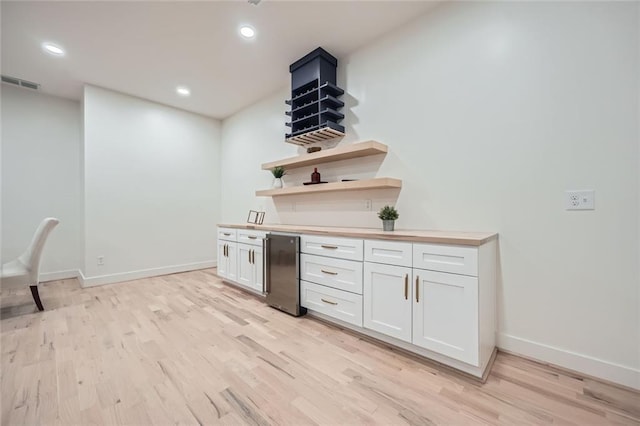 kitchen featuring open shelves, light countertops, visible vents, light wood-style flooring, and white cabinetry