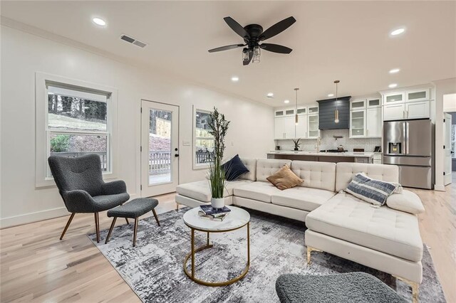 living area with light wood finished floors, baseboards, visible vents, ceiling fan, and recessed lighting