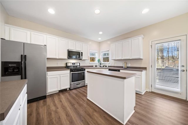 kitchen with dark hardwood / wood-style flooring, white cabinetry, a center island, and stainless steel appliances