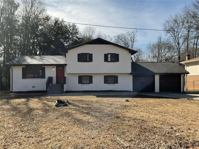 split level home with brick siding, an attached garage, entry steps, crawl space, and driveway