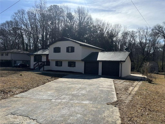 split level home with concrete driveway and an attached garage