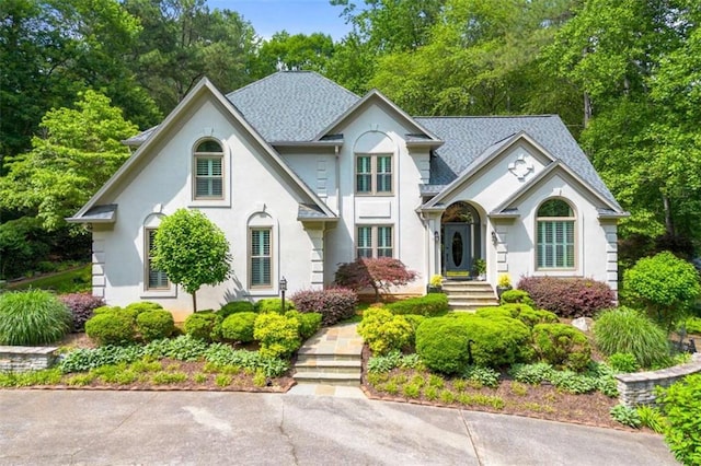 312 Crabapple Springs Way, Woodstock, GA 30188 - view of front facade with stucco siding, view of scattered trees, and roof with shingles