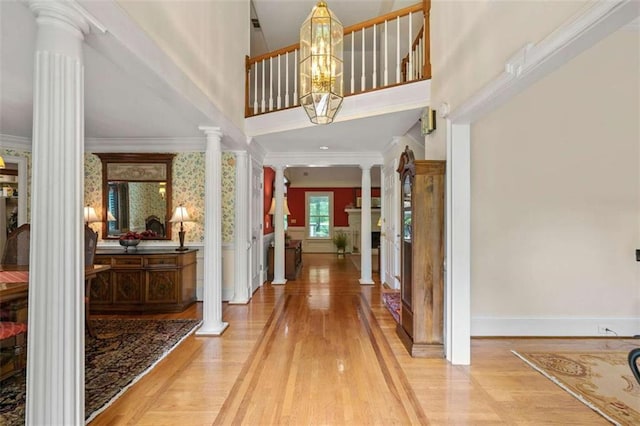 312 Crabapple Springs Way, Woodstock, GA 30188 - foyer entrance featuring decorative columns, ornamental molding, light wood-style floors, baseboards, and a chandelier