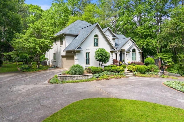 312 Crabapple Springs Way, Woodstock, GA 30188 - view of front of house featuring asphalt driveway, stucco siding, view of scattered trees, and roof with shingles