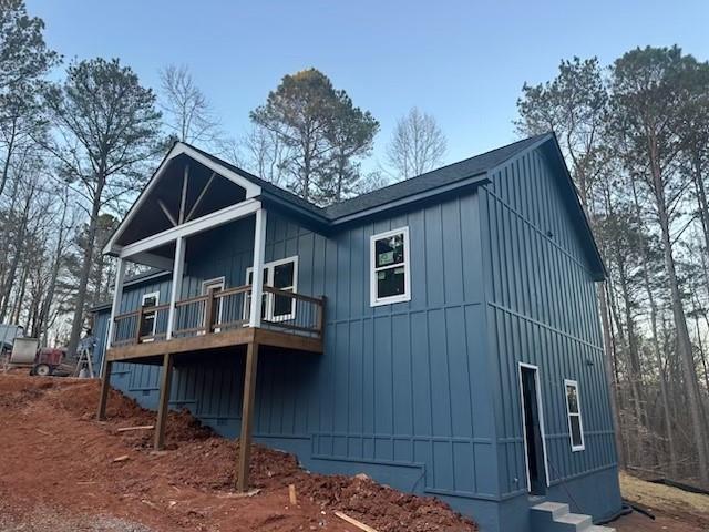 view of side of property with board and batten siding and a wooden deck