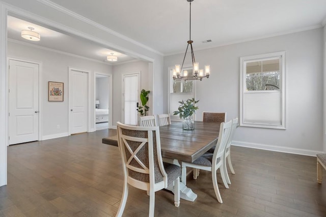 dining area featuring dark wood-style flooring, ornamental molding, baseboards, visible vents, and a notable chandelier