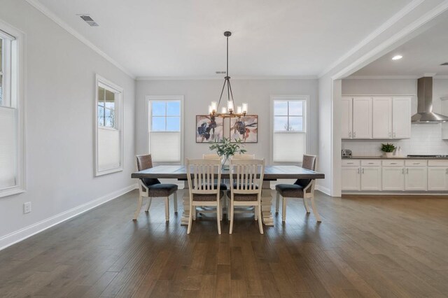 kitchen featuring wall chimney exhaust hood, hanging light fixtures, an island with sink, stainless steel appliances, and white cabinets