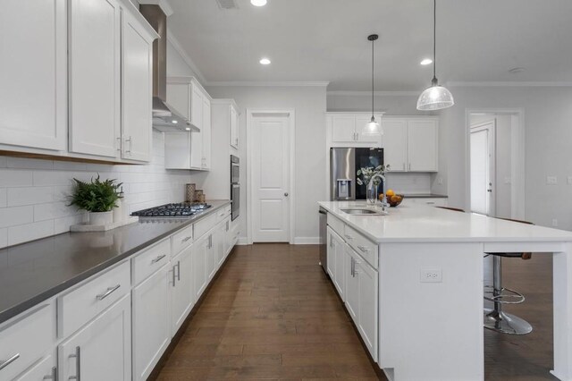 kitchen featuring a kitchen breakfast bar, stainless steel appliances, dark wood-type flooring, a sink, and wall chimney exhaust hood