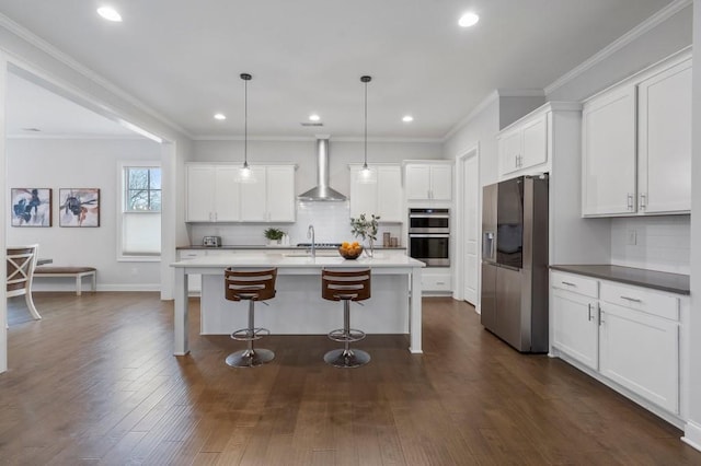 kitchen featuring white cabinetry, a kitchen bar, dark wood-style flooring, wall chimney range hood, and appliances with stainless steel finishes