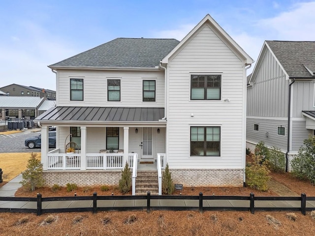 modern inspired farmhouse featuring metal roof, brick siding, a standing seam roof, roof with shingles, and covered porch