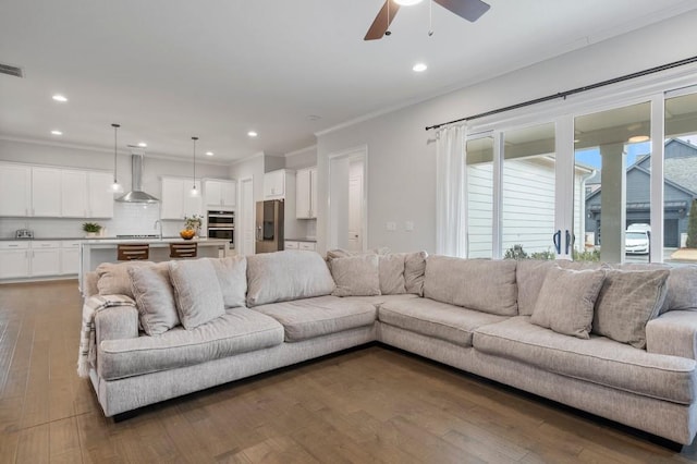 living room featuring visible vents, ornamental molding, wood finished floors, recessed lighting, and a ceiling fan