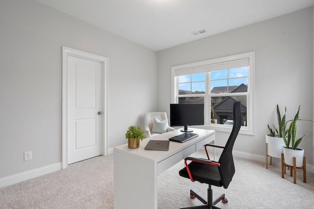 office space featuring light colored carpet, visible vents, and baseboards