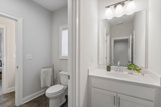 bathroom featuring toilet, vanity, baseboards, and visible vents