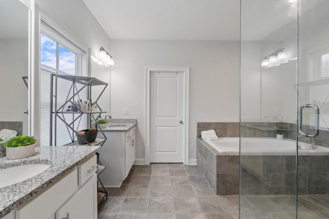 full bathroom featuring a sink, two vanities, a stall shower, and a garden tub