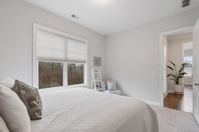 carpeted bedroom featuring baseboards and visible vents