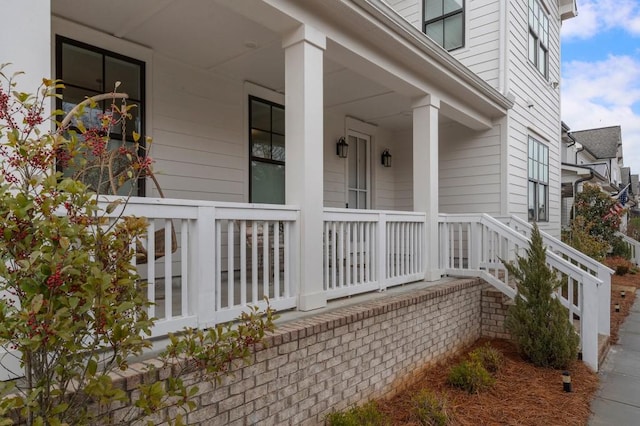 view of exterior entry featuring covered porch