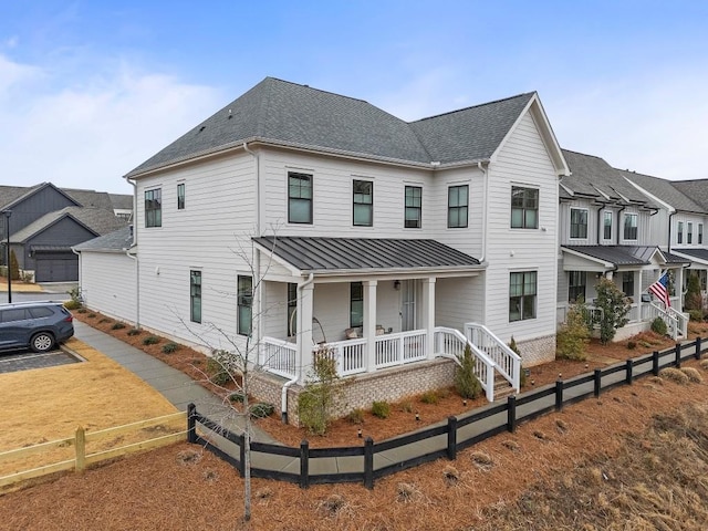 view of front of house with covered porch and a shingled roof