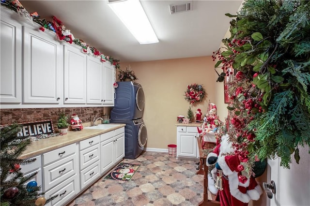 261 Double Springs Rd SW, Monroe, GA 30656 - laundry room featuring stacked washer and clothes dryer, cabinet space, and baseboards