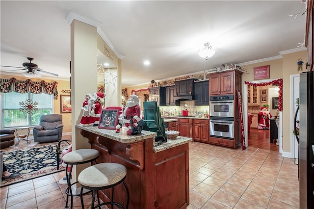 261 Double Springs Rd SW, Monroe, GA 30656 - kitchen with stainless steel appliances, light tile patterned floors, a kitchen bar, crown molding, and a peninsula