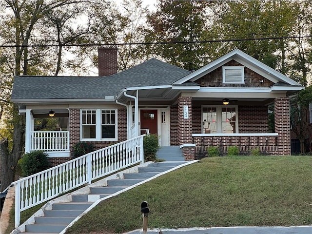 view of front of property with ceiling fan, a porch, and a front yard