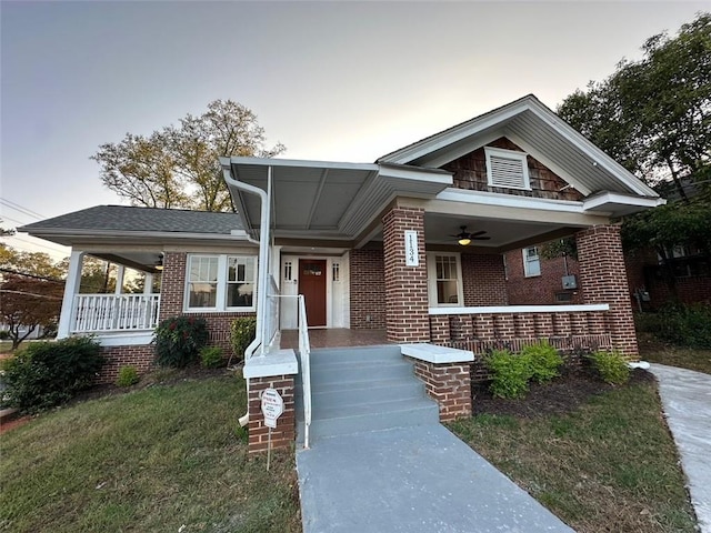 view of front of home featuring a lawn, ceiling fan, and a porch