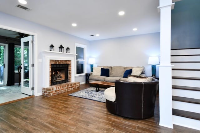 1206 Shiloh Cir NW, Kennesaw, GA 30144 - living room featuring a brick fireplace, wood finished floors, decorative columns, recessed lighting, and stairway