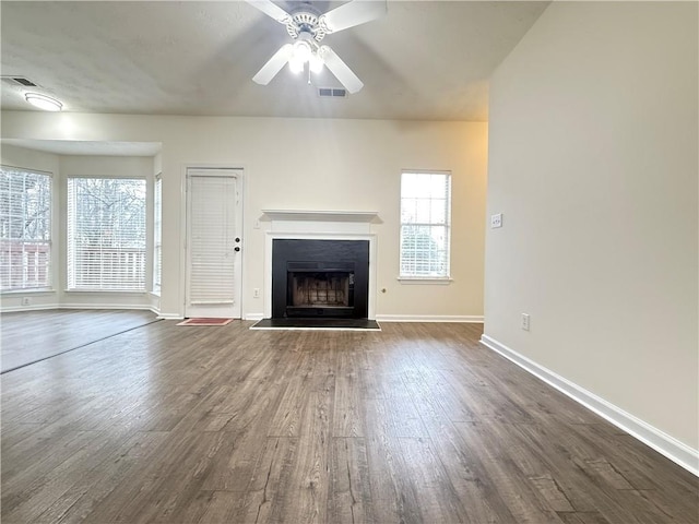 unfurnished living room featuring visible vents, a fireplace, baseboards, and dark wood-style flooring