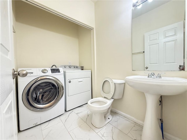 half bathroom with independent washer and dryer, baseboards, toilet, and marble finish floor