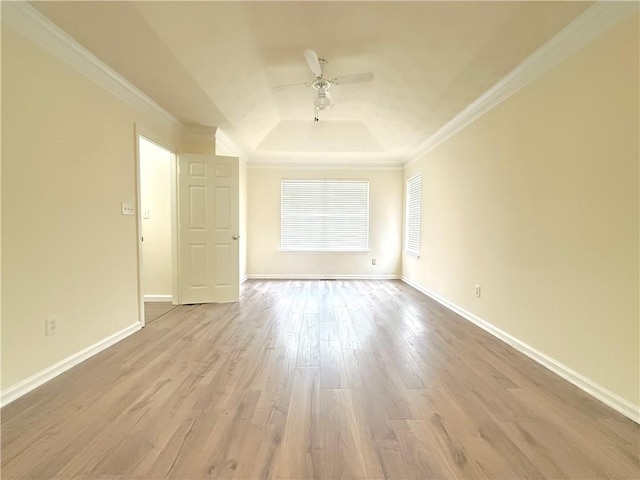 spare room with baseboards, ornamental molding, wood finished floors, a raised ceiling, and a ceiling fan