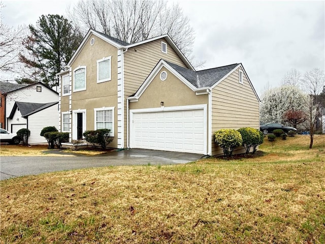 traditional-style house with stucco siding, driveway, a front lawn, and a garage