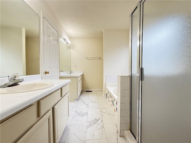 full bathroom with a textured ceiling, a shower stall, marble finish floor, and a sink